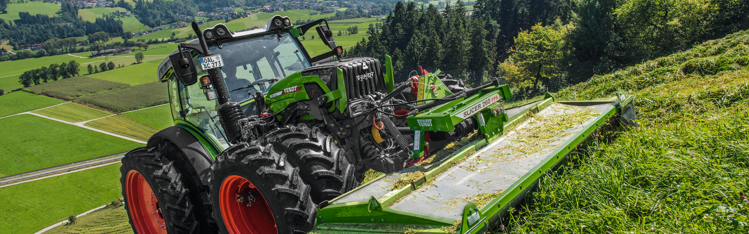 Fendt Slicer 260 Vario trabajando en una pendiente en un pastizal.