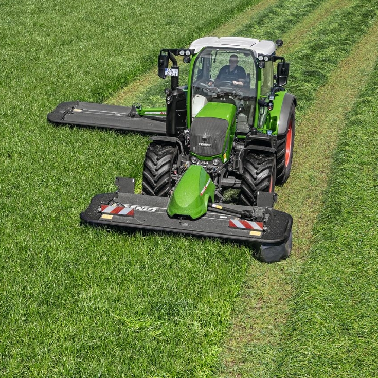 Vista superior de un agricultor segando un prado con una segadora frontal y trasera Fendt Slicer.