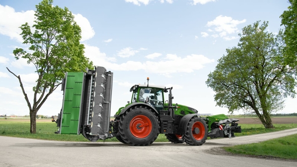 Tractor Fendt Vario verde visto desde detrás con elevador plegado en la carretera