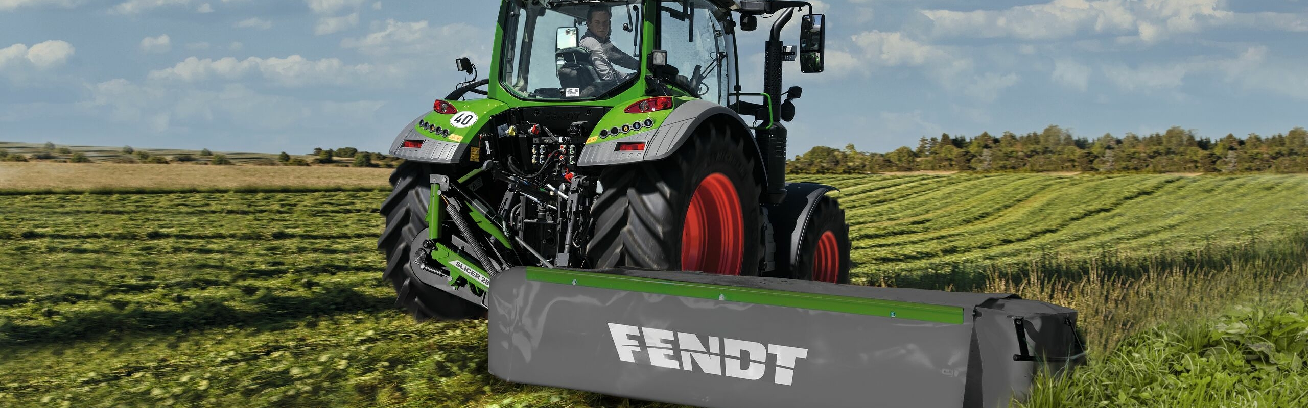 Fendt Slicer ISL trabajando enganchada en un tractor Fendt verde.