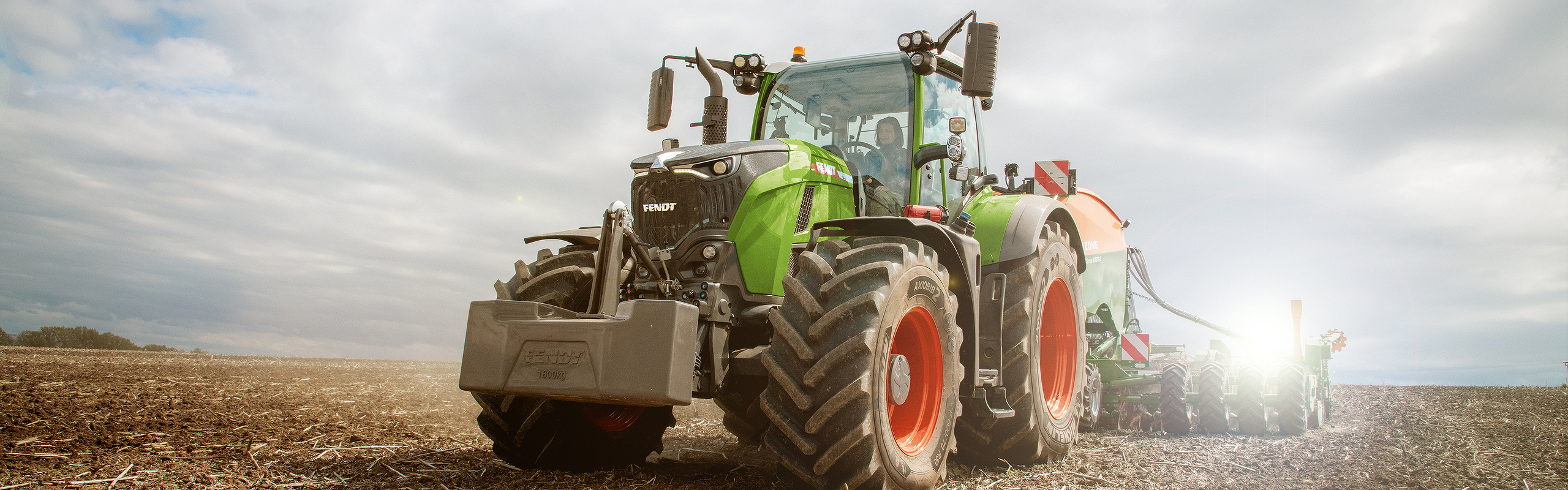 Un tractor Fendt 700 Vario Gen7 circula por un prado y levanta polvo.