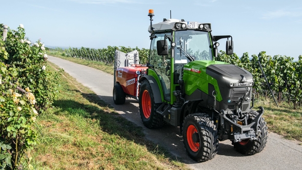 Un Fendt e100 V Vario con pintura verde circula por un viñedo