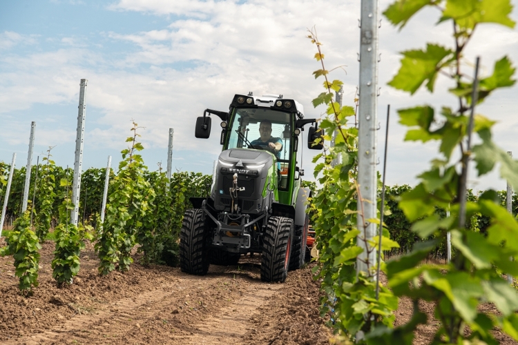 El Fendt e100 V Vario circula con una sembradora por un viñedo