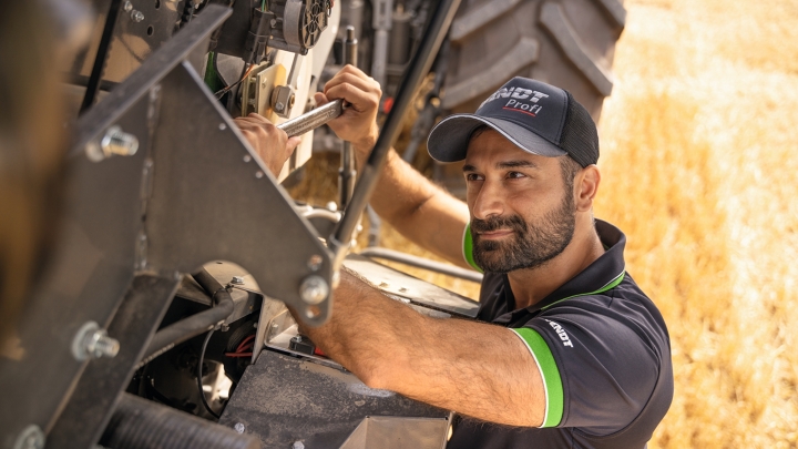 Un trabajador de servicio Fendt reparando una máquina directamente en el campo