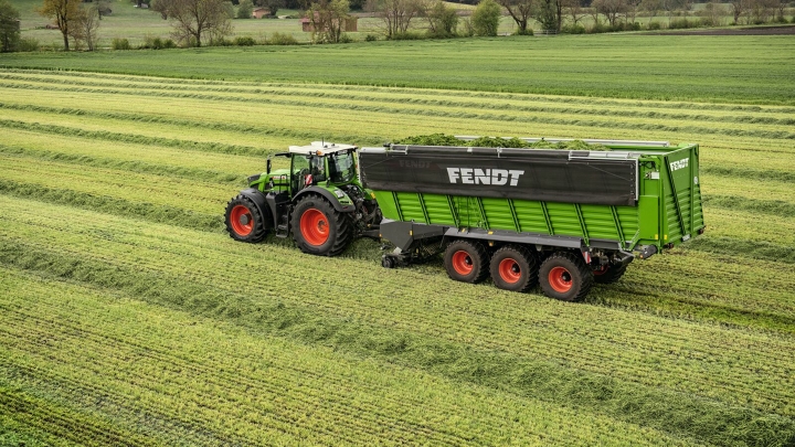 Un agricultor conduce un tractor Fendt y un remolque autocargador Tigo 90 XR en el campo.