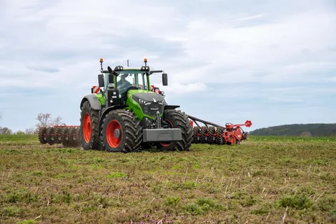 Fendt 1000 Vario ajaa pellolla pilvisellä säällä asennetun työkoneen kanssa.