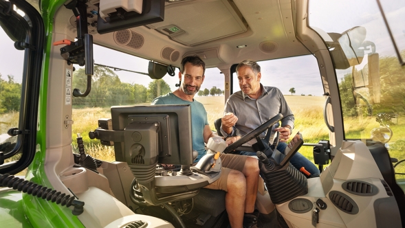 Fendt-jälleenmyyjä ja asiakas Fendt traktorilla esittelyyn.