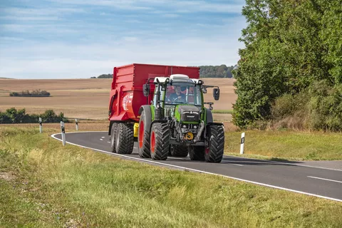 Agriculteur sur la route avec un Fendt 200 Vario et une remorque autochargeuse