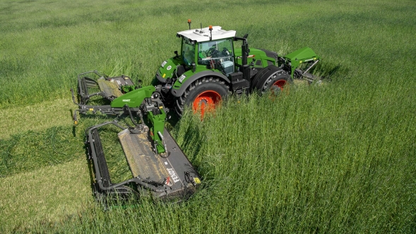 Un agriculteur conduit un Fendt 900 Vario et fauche une prairie avec un Fendt Slicer monté à l'avant et à l'arrière.