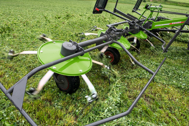 Közelkép néhány Fendt Lotus rotorról és kerékről munka közben egy zöld mezőn