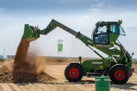 Telehandler Fendt Cargo T740 in operation with bucket and lifted lift cabin