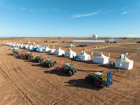 one row of Fendt tractors with attachements waiting for their show at Fendtgüinoshite tents behind them