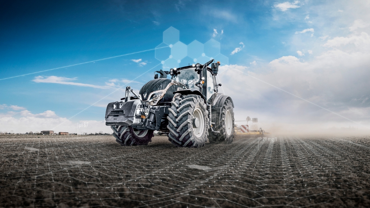 A black Valtra tractor is parked in a field.