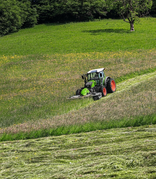 Fendt 200 Vario with Fendt Slicer in steep grassland mowing the field.