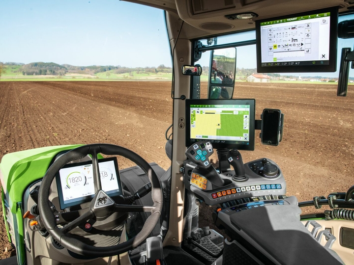 Close-up of the cab of the Fendt 700 Vario Gen6 with a view of the three terminals at the front behind the steering wheel and on the right on the armrest and in the roof liner.