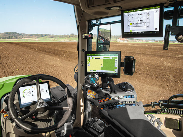 Close-up of the cab of the Fendt 700 Vario Gen6 with a view of the three terminals at the front behind the steering wheel and on the right on the armrest and in the roof liner.