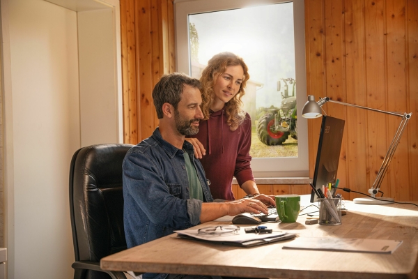 A farmer couple checking their task-related documentation in FendtONE