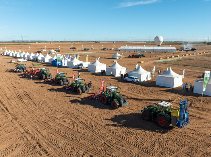 one row of Fendt tractors with attachements waiting for their show at Fendtgüinoshite tents behind them