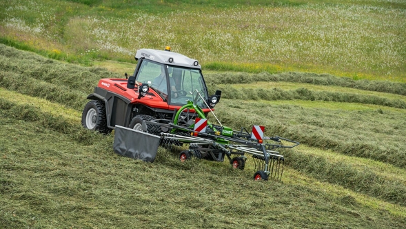 Green Fendt Former in use on a mountain meadow, the swath marks left behind can already be seen in the background.