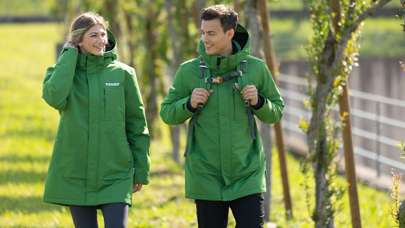 Una donna e un uomo che indossano un Fendt Parker verde e vanno a fare una passeggiata