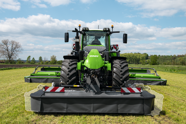 Vista frontale di un trattore Fendt con falciatrice anteriore e posteriore.