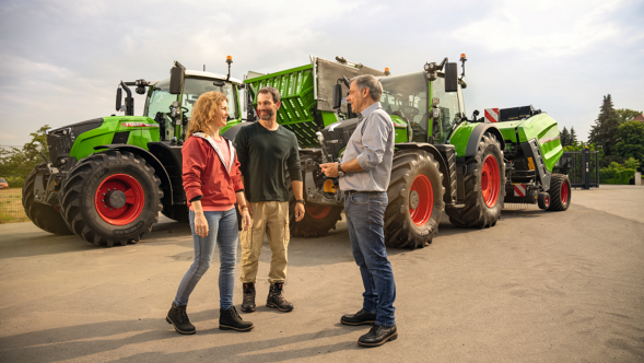 „Fendt“ prekybininkas sveikinasi su ūkininkų pora, atvykusių į „Fendt“ traktoriaus „700 Vario“ ir krautuvinės priekabos „Tigo“ demonstracinį aptarnavimą