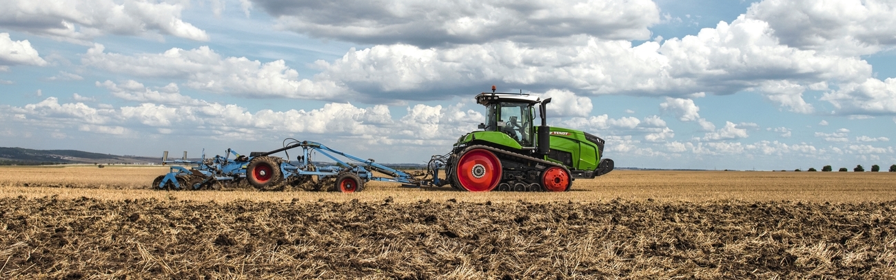 Kāpurķēžu traktors Fendt 900 Vario MT ar zilu disku kultivatoru uz lauka