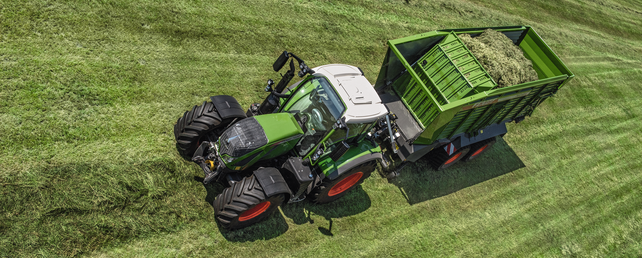 Gaisa fotouzņēmums ar Fendt 700 Vario un Fendt Tigo divkāršo pašiekrāvējpiekabi pļavas vidū.