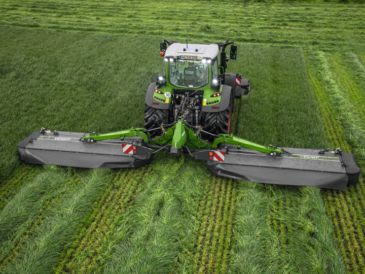 Fendt 500 Vario ar Fendt Slicer pļaujmašīnu uz lauka zāles pļaušanas laikā.