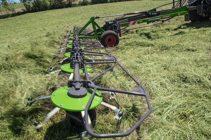 Fendt Lotus 1020 T un 1250 T transportēšanas riteņi darbībā nopļautas zāles ārdīšanas laikā zaļā pļavā