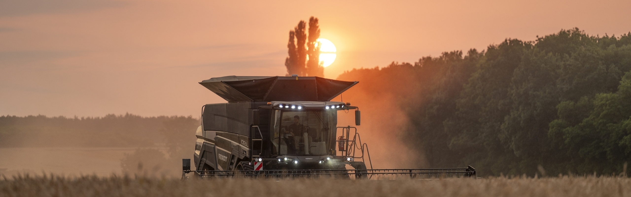 Fendt IDEAL 10 T tīrumā saulrieta laikā