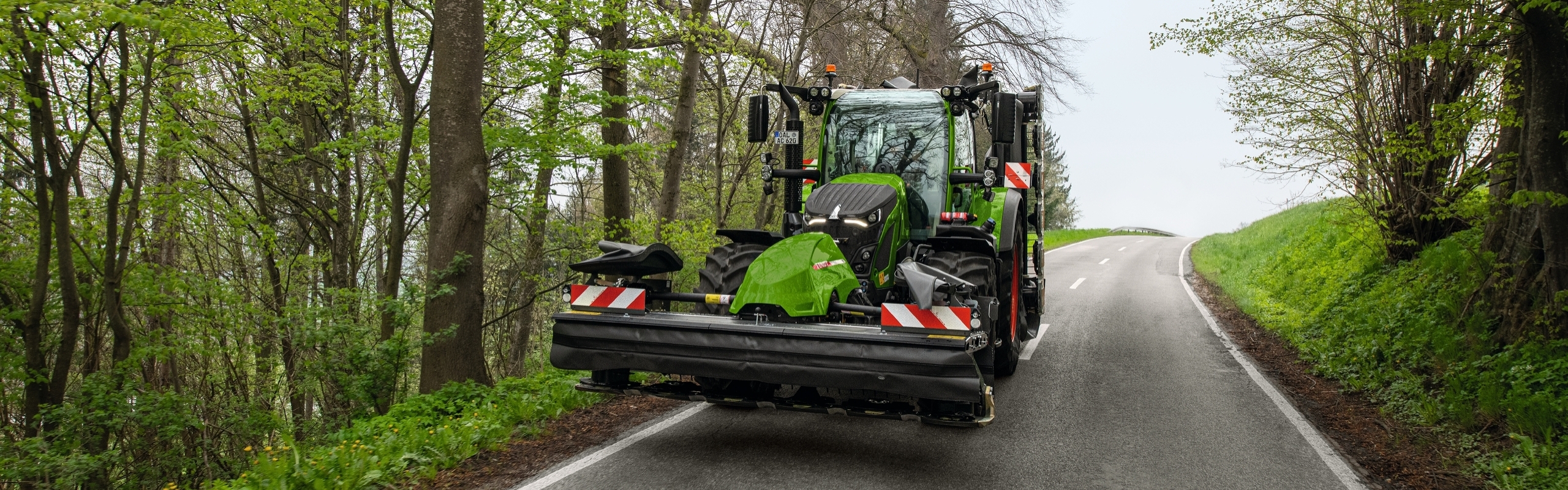 Fendt 600 Vario ar pļaujmašīnu brauc pa ielu