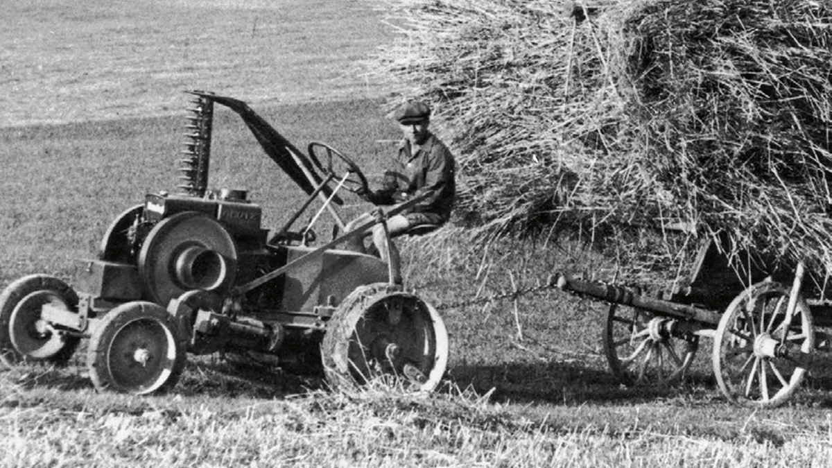 Melnbalts fotoattēls, kurā lauksaimnieks brauc ar Fendt dīzeļdzinēju zirgu pa pļavu.