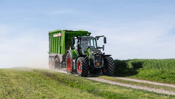 Fendt 600 Vario ar Fendt Tigo savācējpiekabi brauc pa lauku ceļu