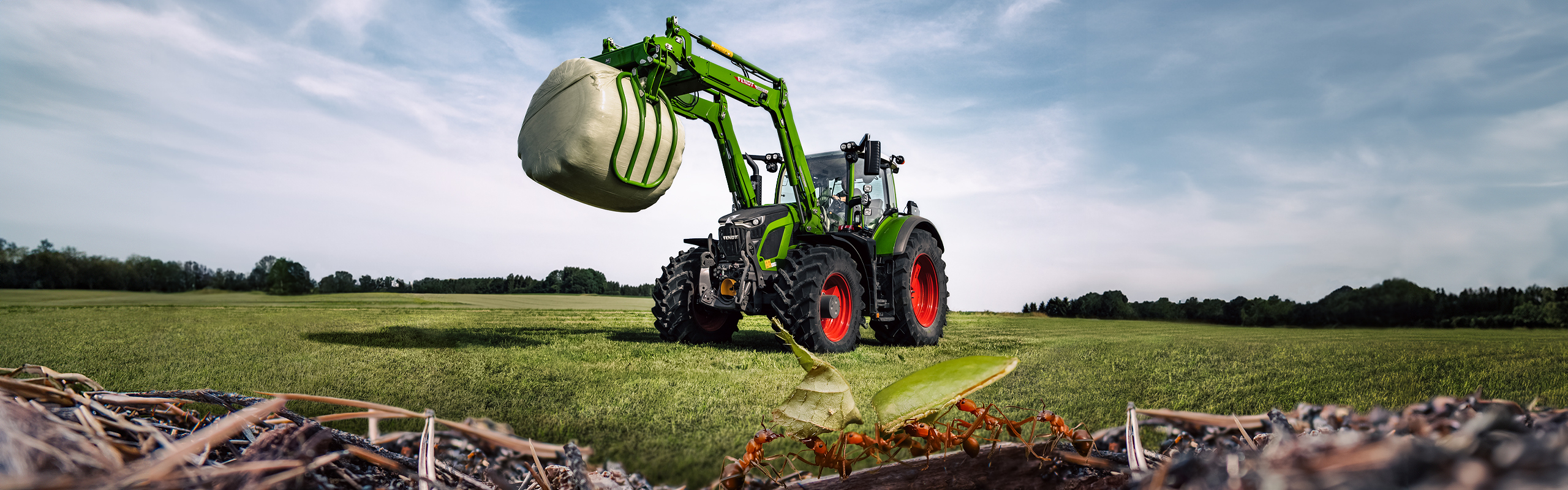 Fendt 600 Vario ar frontālo iekrāvēju uz atsperes ar skudrām priekšplānā