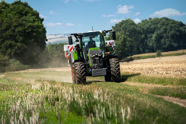 Fendt 600 Vario brauc pa lauka ceļu ar mēslojuma izkliedētāju