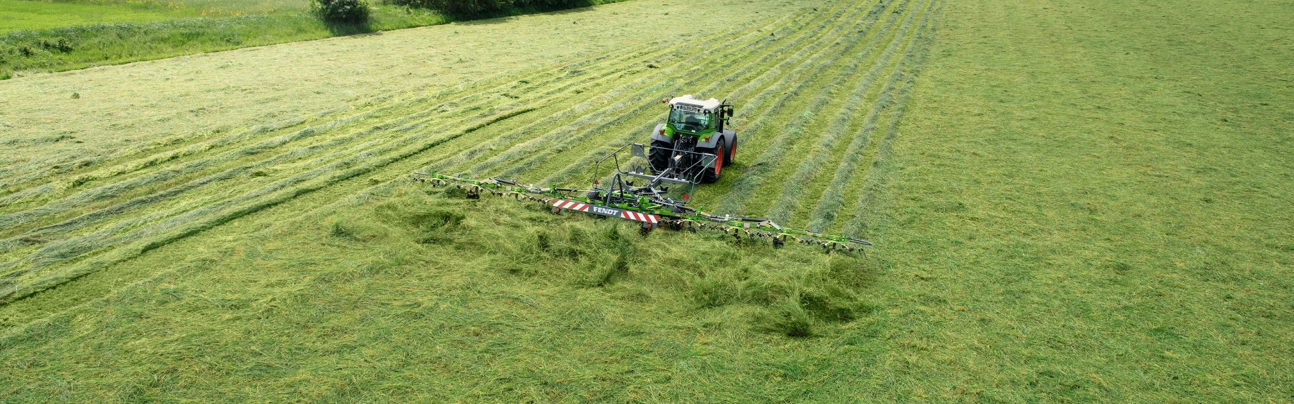 Fendt Twister velkamais siena ārdītājs pļavā - uzņēmums no drona skatu punkta