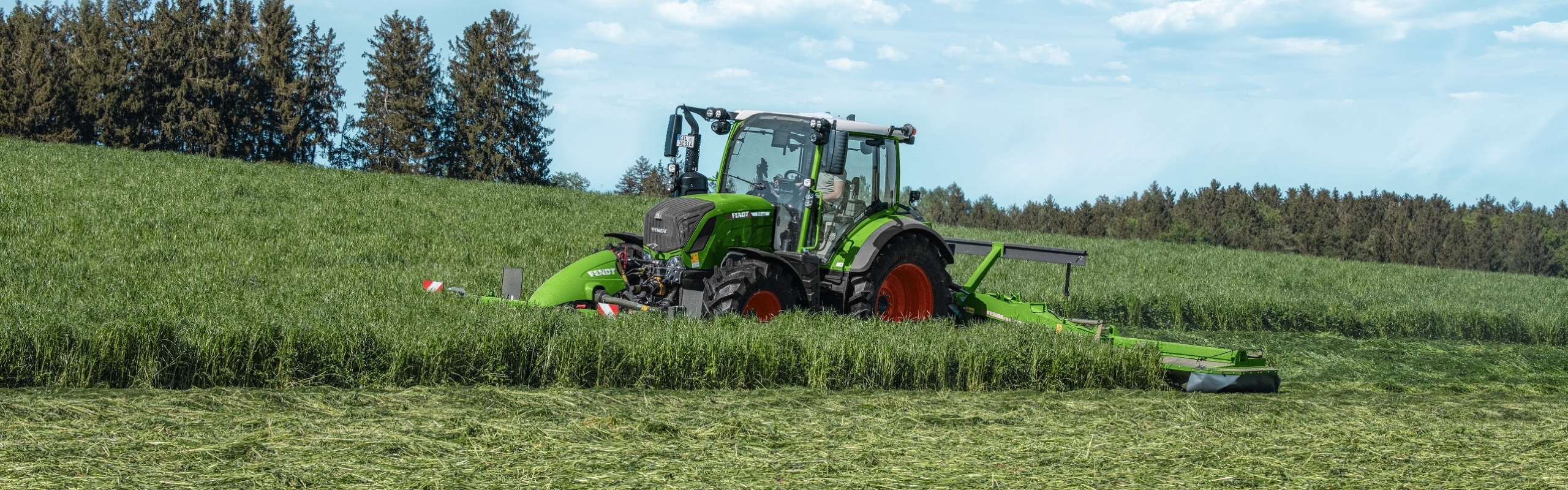 Fendt 300 Vario ar pļaujmašīnām pļavā