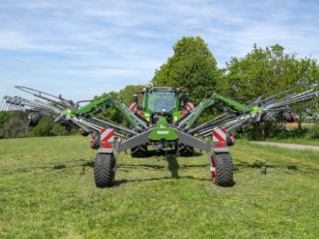 Pļavā stāv traktors ar Fendt Former grābekli.