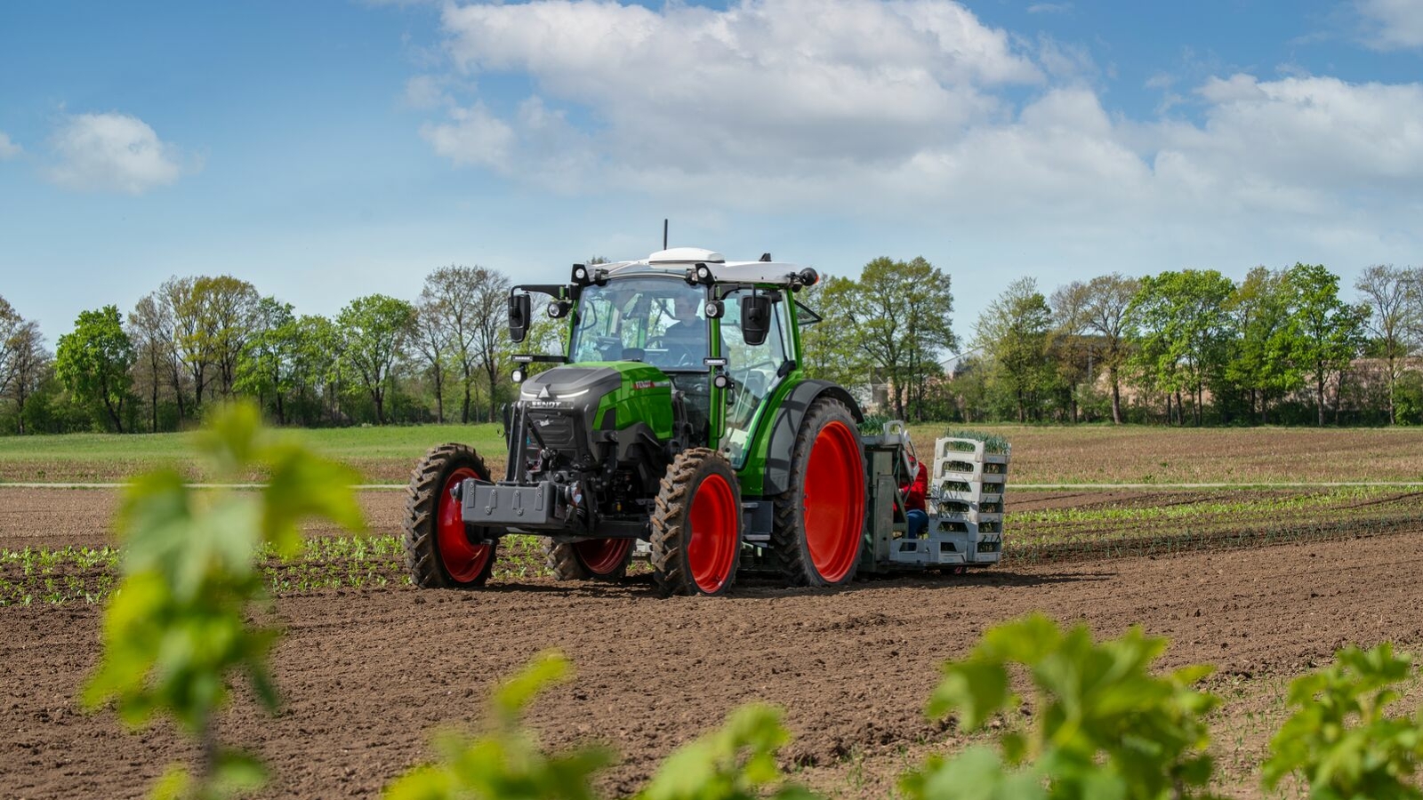 En grønn Fendt e100 i arbeid på jordet