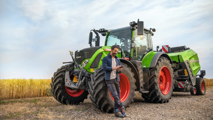 Rolnik z ciągnikiem Fendt kontaktuje się z serwisem Fendt przez smartfona