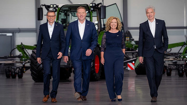 Walter Wagner, Christoph Gröblinghoff, Ingrid Bußjäger-Martin och Ekkehart Gläser står bredvid varandra i Fendt Forum framför en Fendt-traktor och ler.