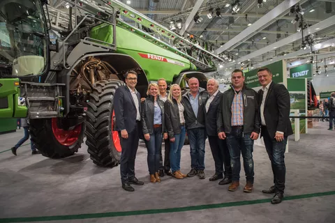 Seven people standing in front of the first Fendt Sprayer