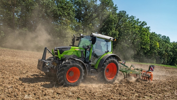 A green Fendt 200 Vario cultivates the field with a cultivator.