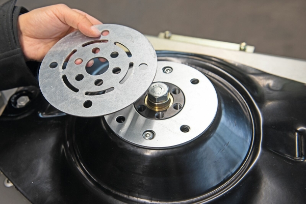 A man holding a Fendt DriveGuard ogverload plate in his hand, presenting it.