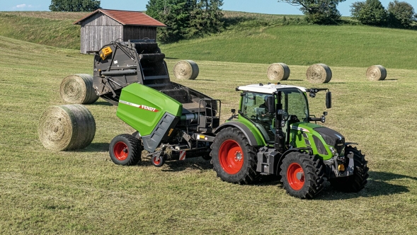 A Fendt tractor with a Fendt Rotana 180V Xtra baler attached in a field baling