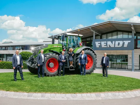 People standing in front of a Fendt tractor in front of the Fendt Forum in Marktoberdorf, Germany.